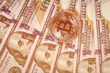 Dollar bills and metal souvenir bitcoin. The concept of electronic money and commerce. Cryptocurrency and cash.の写真素材