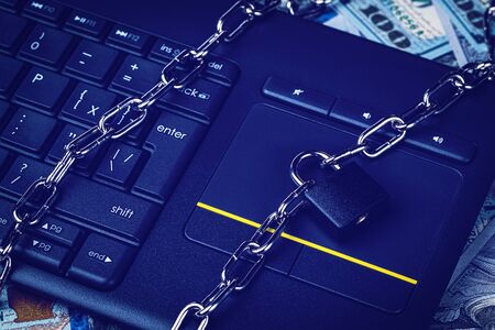 Dollar bills, black keyword and metal chain with lock. The concept of online trading, mining and...