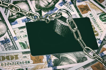 Dollar bills, lock with metal chain and black debit card. The concept of virtual money and commerce blocking or safety. の写真素材