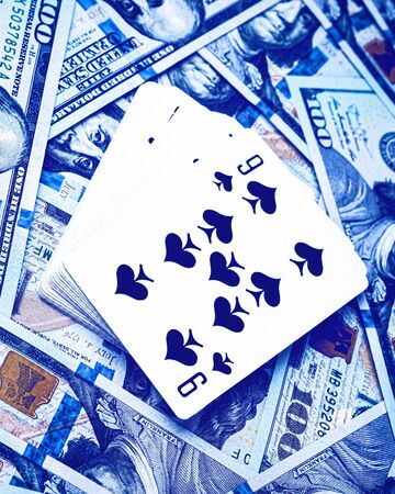 Hundred dollar bills and a deck of playing cards. Money gambling concept.の写真素材