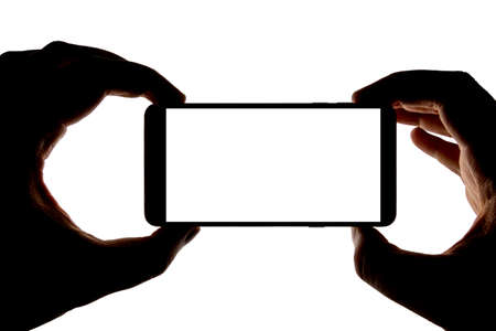 Silhouette of hands with smartphone taking picture isolated on white background. Screen with copy...