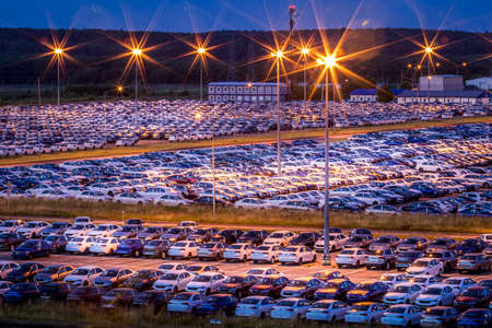 Volkswagen, Russia, Kaluga - AUGUST 26, 2020: New cars parked at distribution center of automobile factory at night with lights. Parking on the open air.のeditorial素材