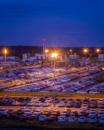 Volkswagen, Russia, Kaluga - AUGUST 26, 2020: New cars parked at distribution center of automobile factory at night with lights. Parking on the open air.のeditorial素材