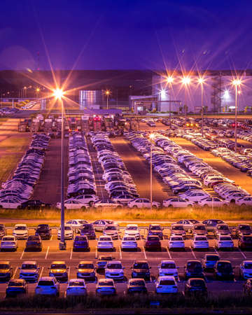 Volkswagen, Russia, Kaluga - AUGUST 26, 2020: New cars parked at distribution center of automobile factory at night with lights. Parking on the open air.のeditorial素材