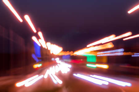Traces of headlights from cars moving at night on the bridge, illuminated by lanterns. Abstract...