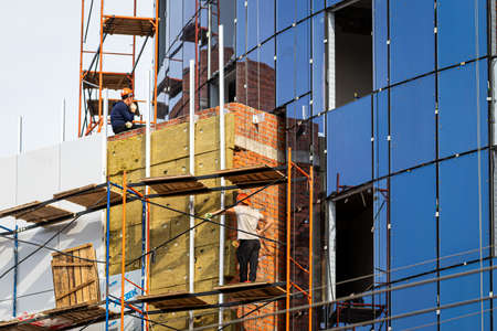 Russia, Kaluga - SEPTEMBER 16, 2020: Builders working on a construction site on a clear sunny day.