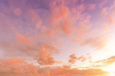 Colorful orange-purple dramatic clouds lit by the setting sun against the evening blue sky.