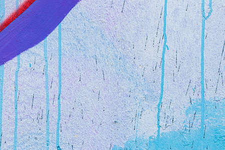 A fragment of colorful graffiti painted on a concrete wall. Abstract urban background for design.