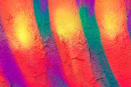 A fragment of colorful graffiti painted on a concrete wall. Abstract urban background for design.