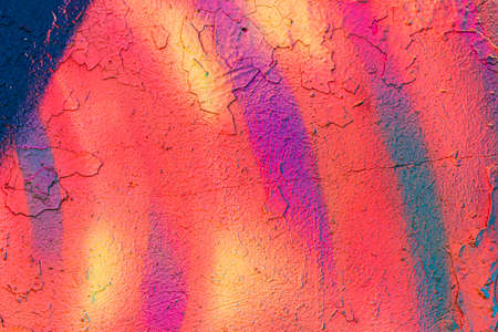 A fragment of colorful graffiti painted on a concrete wall. Abstract urban background for design.