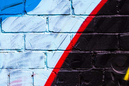 A fragment of colorful graffiti painted on a brick wall. Abstract background for design.の写真素材