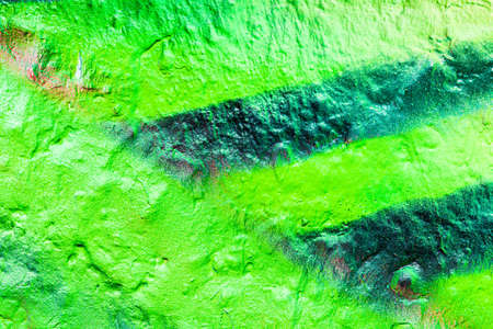 A fragment of colorful graffiti painted on a concrete wall. Abstract urban background for design.