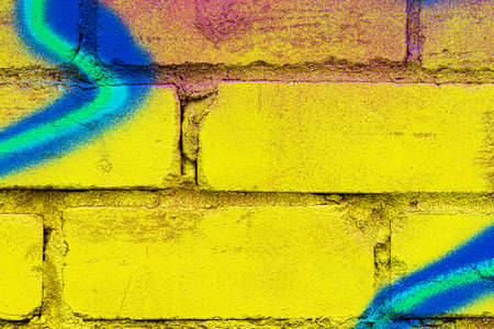 A fragment of colorful graffiti painted on a brick wall. Abstract background for design.
