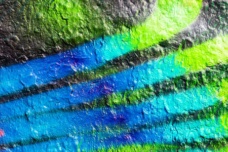 A fragment of colorful graffiti painted on a concrete wall. Abstract urban background for design.