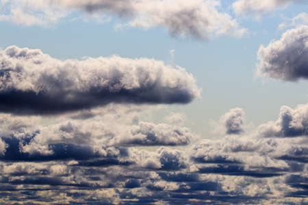 Bright blue sky with dramatic cumulus clouds lit by the daytime sun. Abstract background.