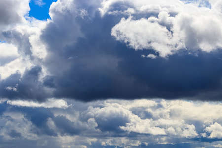 Bright blue sky with dramatic cumulus clouds lit by the daytime sun. Abstract background.の写真素材