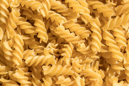 Top view of Italian uncooked fusilli pasta. Food texture.