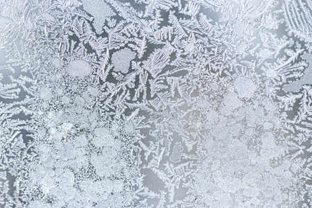 The texture of the glass covered with frost in winter in cold weather. Abstract natural background.