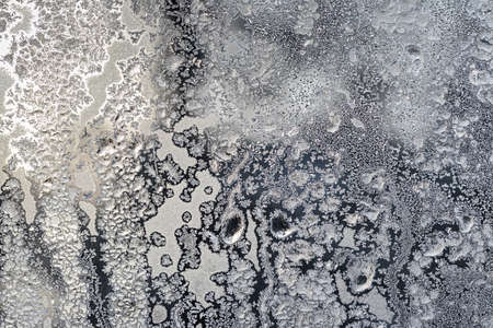 The texture of the glass covered with frost in winter in cold weather. Abstract natural background.の写真素材