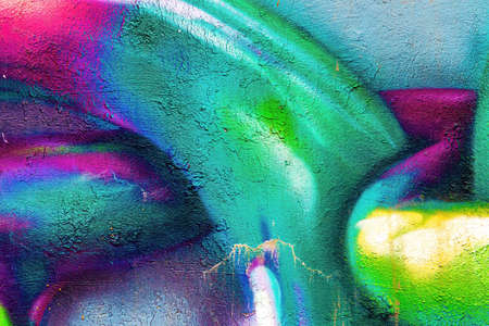 A fragment of colorful graffiti painted on a wall. Abstract urban background for design.