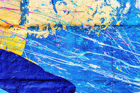 A fragment of colorful graffiti painted on a wall. Abstract urban background for design.