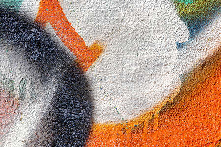 A fragment of colorful graffiti painted on a wall. Abstract urban background for design.