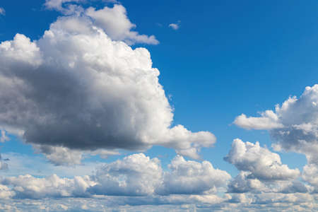 White cumulus fluffy clouds In a blue sky. Background from clouds.