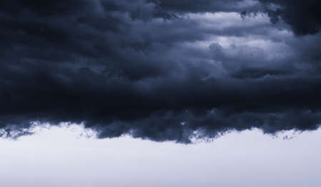 Dark monochrome heavy storm clouds before a thunderstorm or hurricane. Dramatic clouds in overcast...