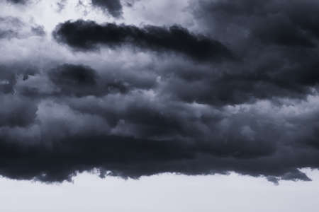 Dark monochrome heavy storm clouds before a thunderstorm or hurricane. Dramatic clouds in overcast...