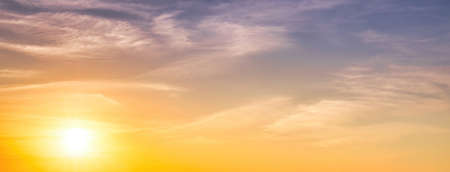 Colorful dramatic clouds lit by a sun against the sunset or sunrise sky. Cloudscape.