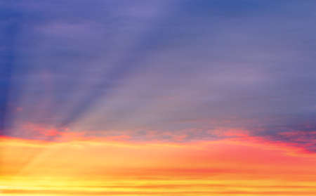 Dramatic cloudy sky at sunset or sunrise. The sun's rays breaking through the clouds.