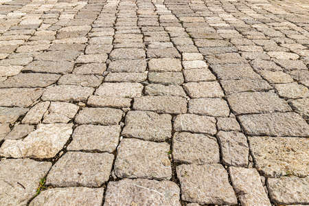 Monochrome old cobblestone pavement texture. Ancient sidewalk background.