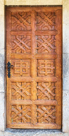Old brown antique wooden door in a wall built of stone.の写真素材