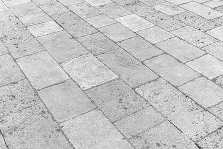 Black and white old cobblestone pavement texture. Ancient sidewalk background.