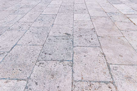 Monochrome old cobblestone pavement texture. Ancient sidewalk background.の写真素材