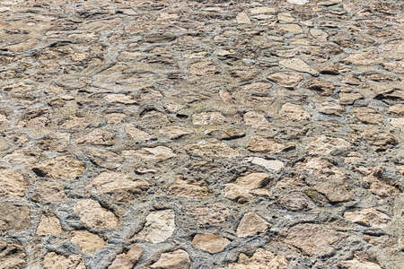 Monochrome old cobblestone pavement texture. Ancient sidewalk background.