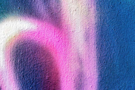 A fragment of colorful graffiti painted on a wall. Abstract urban background for design.