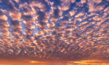 Dramatic cloudy sky illuminated by the rays at sunset or sunrise.の写真素材