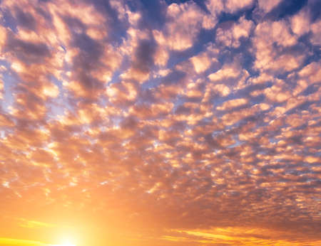 Dramatic cloudy sky illuminated by the rays at sunset or sunrise.の写真素材