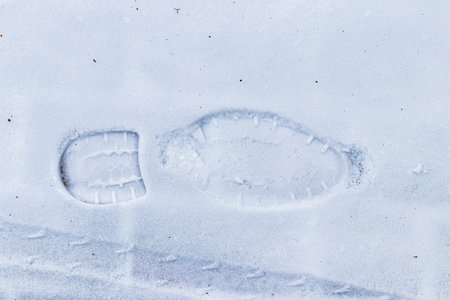 Boot track on thin first snow in winter. Winter concept.