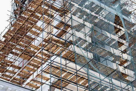 Scaffolding without people on the reconstruction of a historic building on a cloudy day.