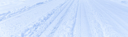 Texture of a snowy road with traces of car tires. Winter driving concept.