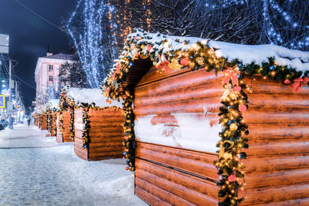 Christmas or New Year's market in a European city with houses decorated with toy balls and garlands at night.の写真素材