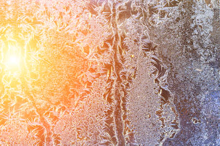 Frost texture on frozen glass illuminated by the sun in winter. Winter background.
