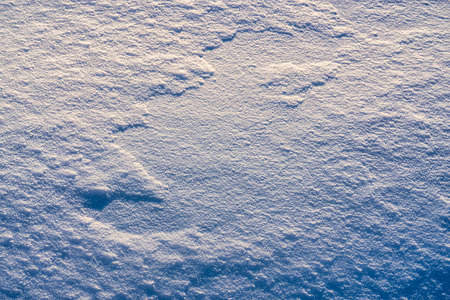 Texture of snow illuminated by sunlight. winter background.