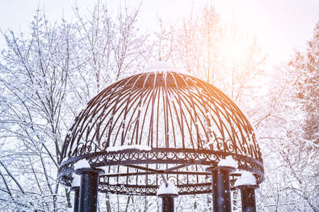 Black metal grate covered with snow and lit by sun in winter. Snowfall and winter weather concept.の写真素材