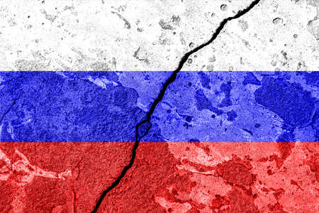 The crack between the Russian Federation and Ukrainian flags on the concrete wall. The concept of sanctions, war, the decline of diplomatic relations, confrontation and severance of agreements.の写真素材