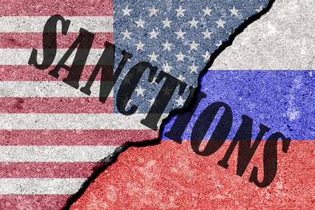 The crack between the Russian Federation and USA flags on the concrete wall. The concept of sanctions.の写真素材