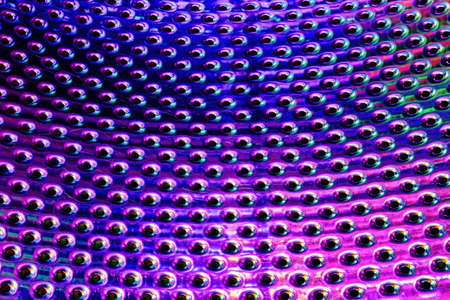 Texture of a stainless steel washing machine drum with holes.