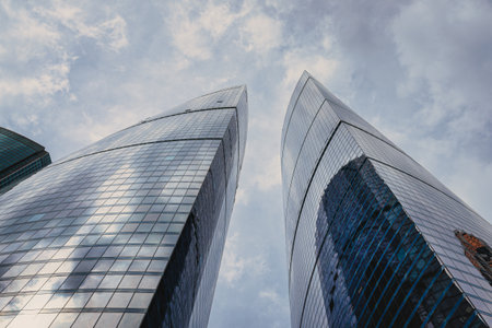 RUSSIA, MOSCOW - JULY 17, 2022: Low angle view of Moscow-City skyscrapers. New business and finance district in Moscow downtown. Tops of modern corporate buildings against the cloudy sky.のeditorial素材